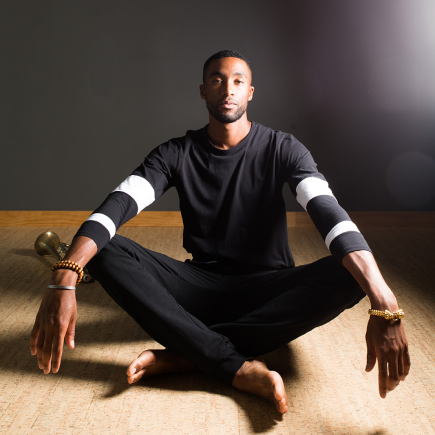 the portrait of yoga instructor Chris Stanley sitting on the floor