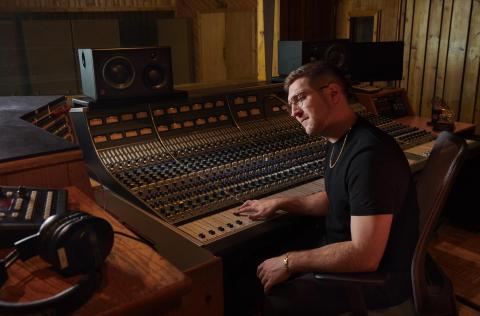 Charlie Rosen '12 behind a mixing board in a studio